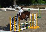 Student and horse jumping fence